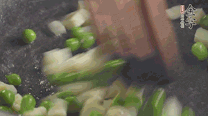 鍋中油7成熱時，入青豆、筍丁翻炒，然后加糯米飯加鹽均勻翻炒。