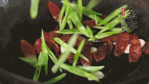 先后下香腸片、四季豆絲均勻翻炒，加適量清水燜煮一下。