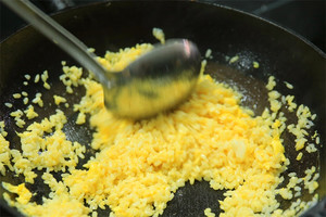 大火加熱炒鍋，再入油，燒到四至五成熱時倒入雞蛋液，在未凝結(jié)之前，加米飯煸炒，不停翻炒并用鍋鏟將成塊的米飯碾開、撥散。