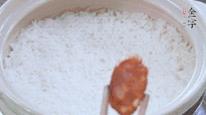 煮開后轉(zhuǎn)小火，當(dāng)米飯出現(xiàn)小孔時，鋪上金字麻辣香腸。