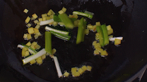 鍋中熱油，依次下姜粒、蔥段、蘆筍炒香。