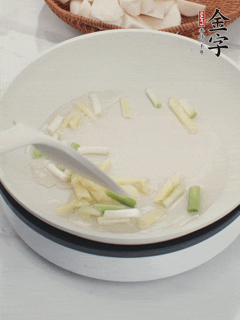 鍋中油五成熱，下蔥白、姜片爆香。