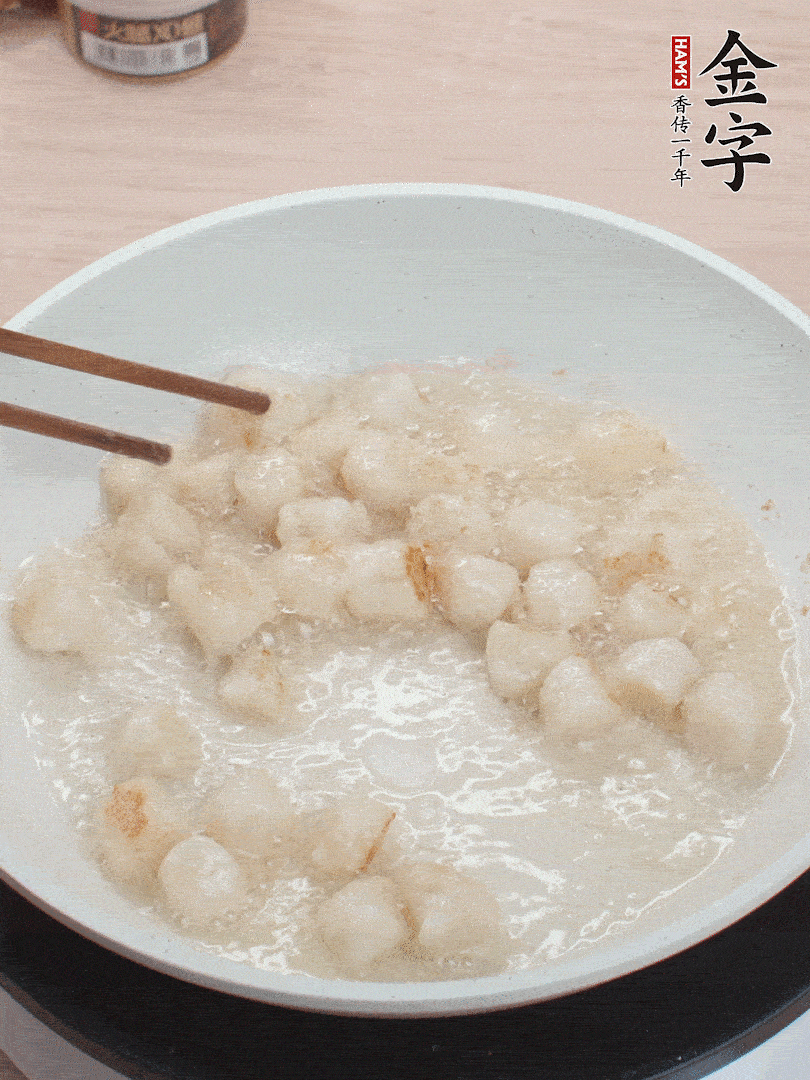 油溫4成熱，鮮貝蘸干淀粉下鍋煎，一面微黃后翻面。