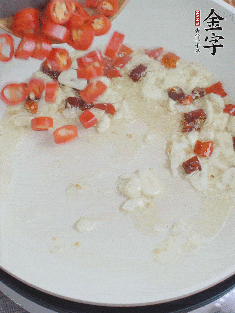 油6成熱，下蒜末、干紅辣椒煸炒，出香味后再放美人椒、香腸。