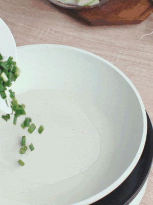 熱油下臘肉、蔥花煸炒，再下西葫蘆。