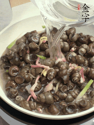 倒處理干凈的螺螄翻炒，加3勺料酒。加清水蓋過螺螄，中火蓋蓋煮5分鐘。