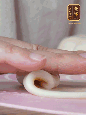 做面劑 油皮按扁，中間包入一個油酥，邊緣收緊捏死。包好的面劑按扁，用搟面杖搟壓成橢圓形。從底部向上卷成筒狀，用保鮮膜蓋好松弛15分鐘，再把筒狀縱向搟壓成長條狀。再卷一次，松弛20分鐘