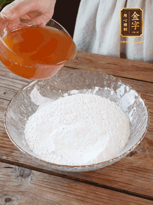 轉(zhuǎn)化糖漿、枧水、花生油攪拌均勻，加入面粉混合，醒發(fā)2小時(shí)。捏成23g一個(gè)的小球